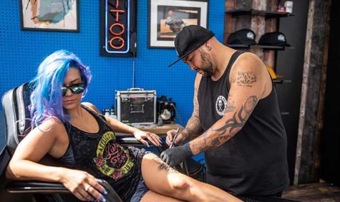 Picture of a woman getting tattooed at Progressive Sturgis event